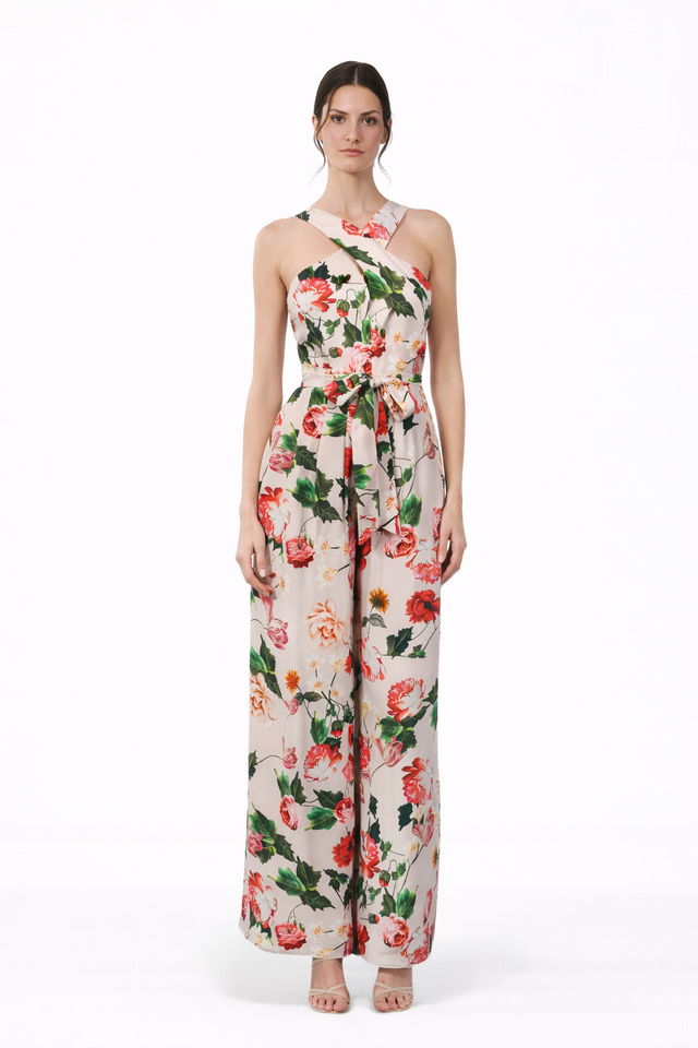 MSA Haute Couture ivory floral jumpsuit with cross-neck halter, tie waist, and wide-leg trousers. Red and green floral print.