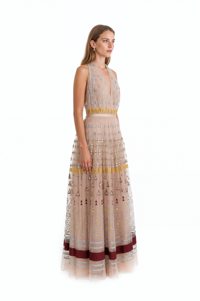 Side view of a Valentino beige geometric appliqué tulle gown with full floor-length skirt