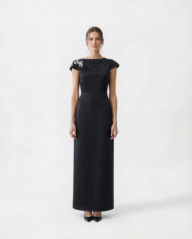 Mikael Aghal black column gown with boat neckline, cap sleeves, and crystal shoulder embellishment – front view