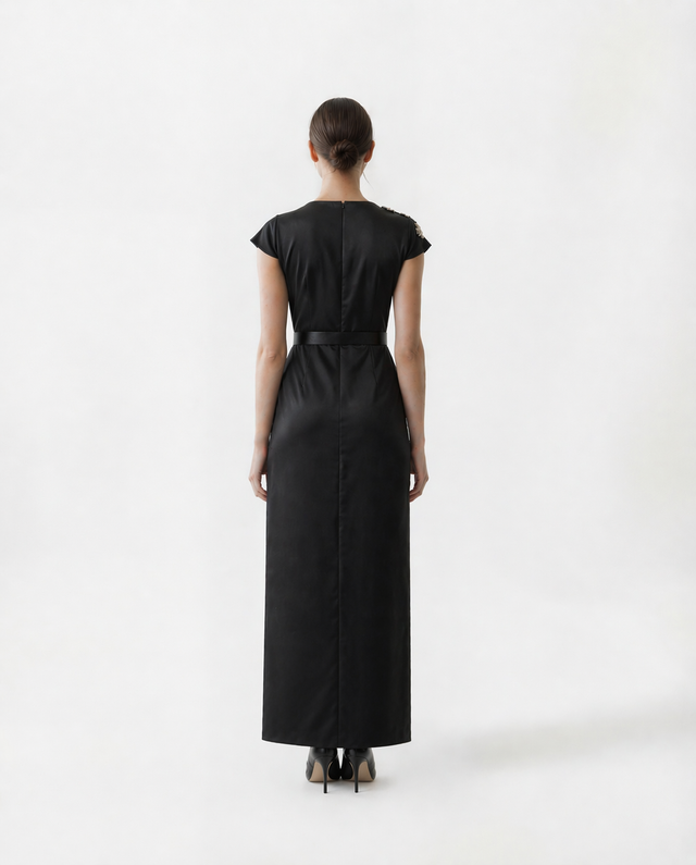 Back view of a black Mikael Aghal column gown with belted waist, concealed zip, and back slit