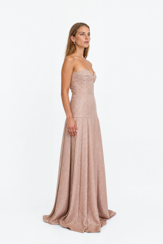 Side view of a Valentino blush sequin drop-waist gown showing the knife-pleated floor-length skirt