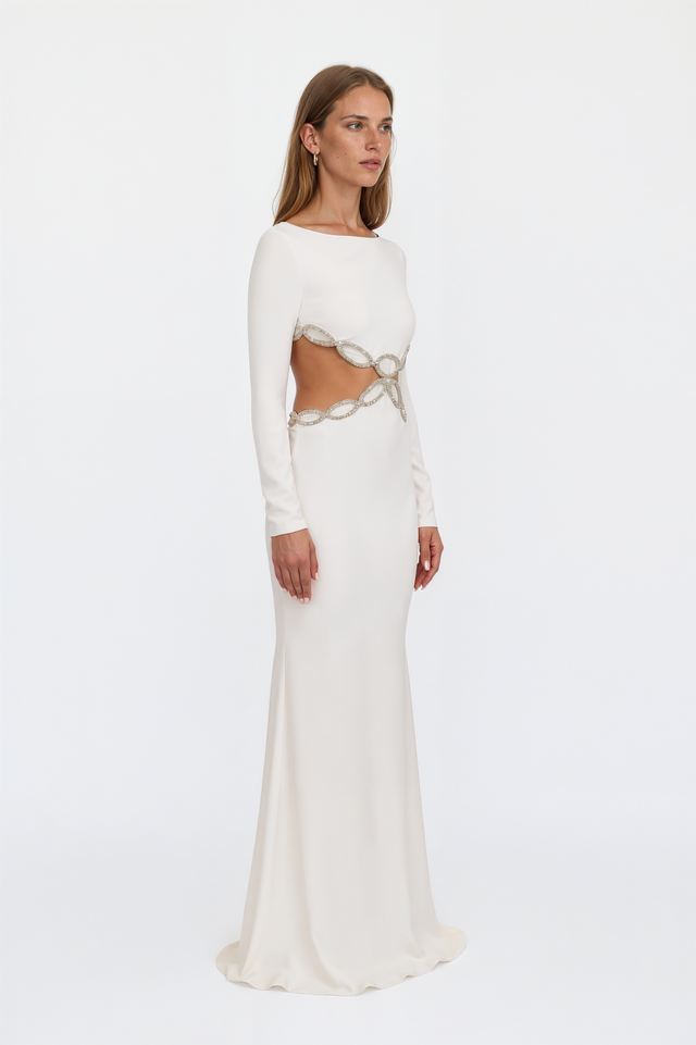 Side view of a Valentino white column gown showing crystal-embellished chain-link cutouts at the waist