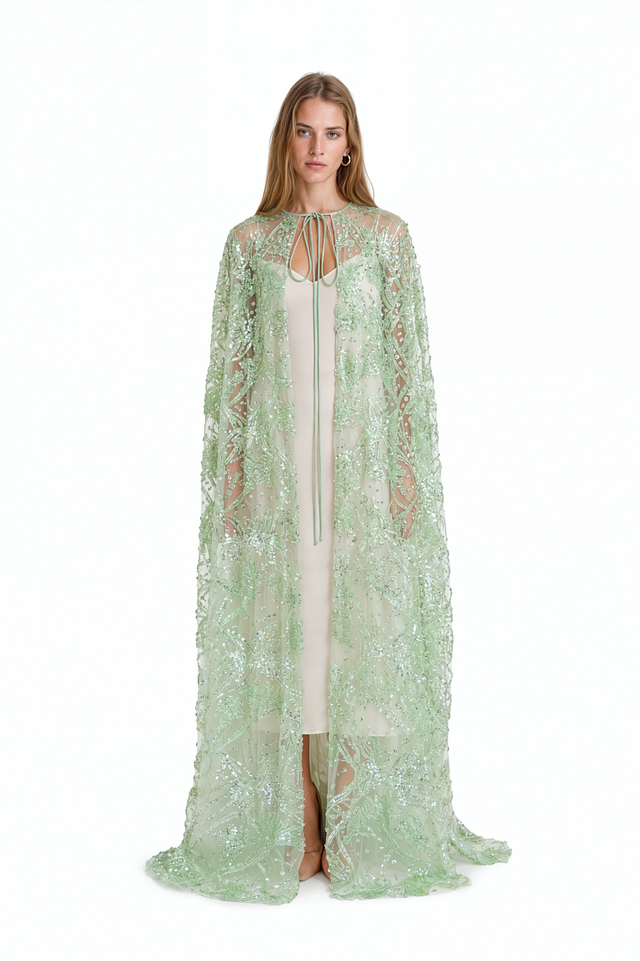 Valentino green beaded sheer tulle cape worn over an ivory slip dress – front view