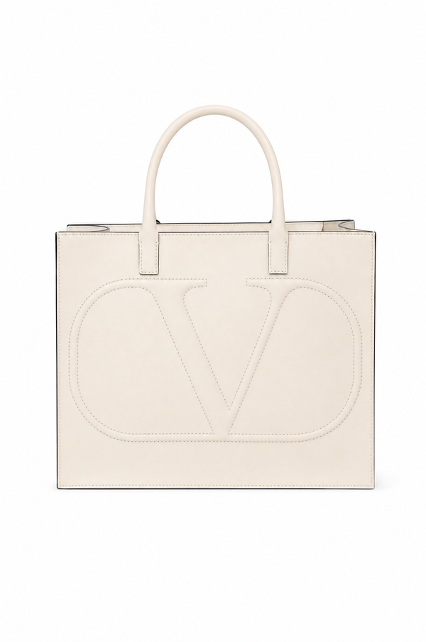 Valentino Garavani off-white leather tote bag with a large embossed 'V' logo on the front, featuring dual top handles and a zip-top closure, shown against a plain white background.