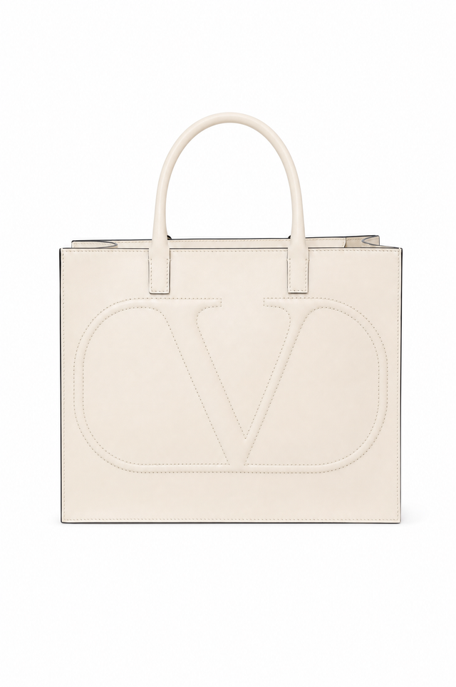 Valentino Garavani off-white leather tote bag with a large embossed 'V' logo on the front, featuring dual top handles and a zip-top closure, shown against a plain white background.