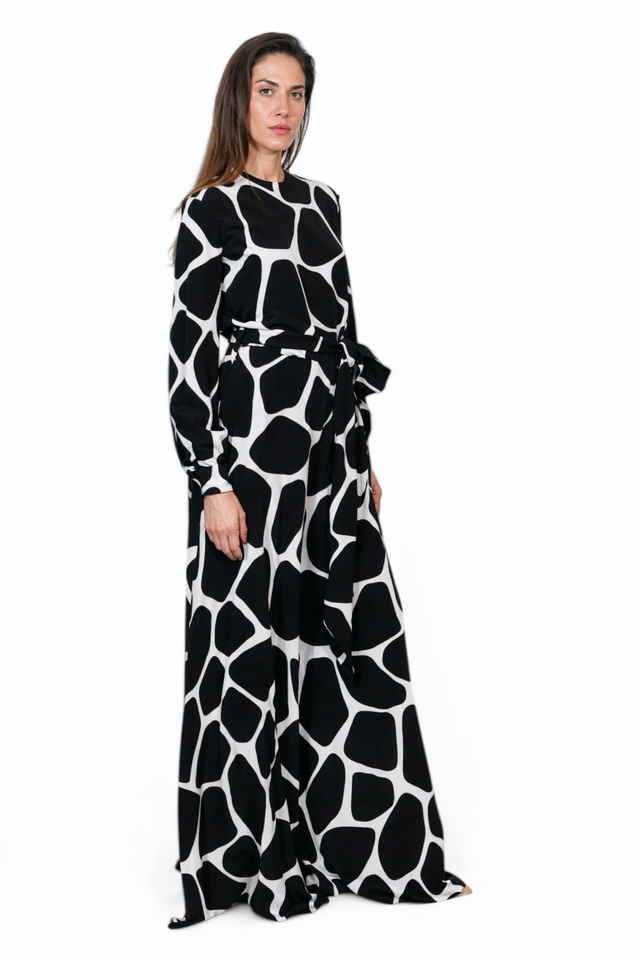 Valentino black and white print jumpsuit, side view on model — long-sleeve design with self-tie belt and wide-leg fit.